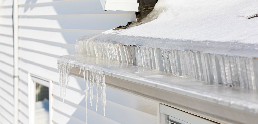 8 Common Causes of a Leaky Roof - Guns N Hoses Roofing Eavestrough full of ice during winter.